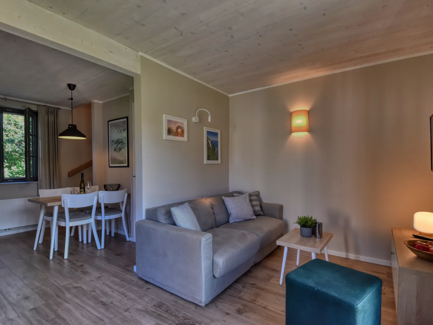 Original: Wohnbereich mit Sofa, Durchgang zum Essplatz und Fenster