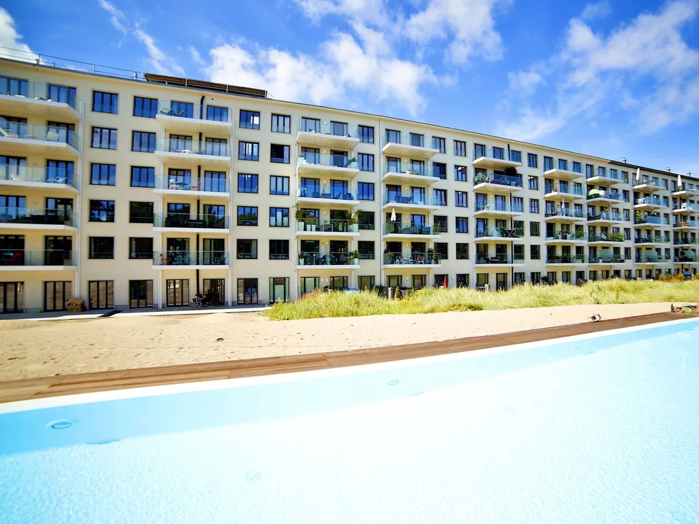 Vorher: Außenanlage mit Pool, Fassade und starkem Sommerlicht